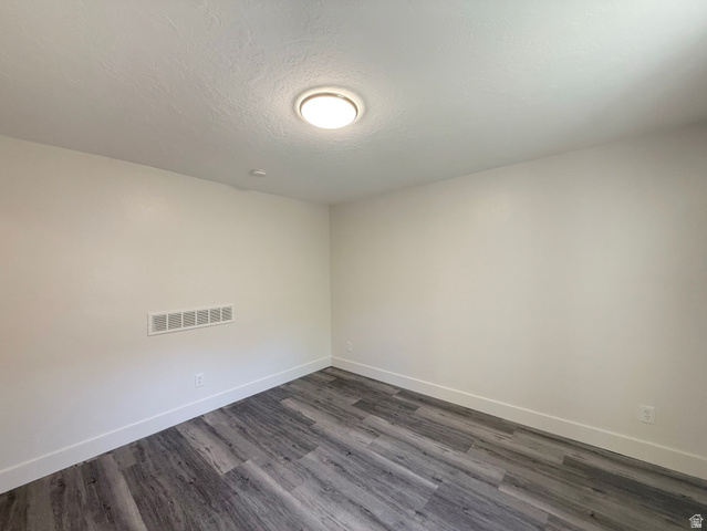 548 27th Street Ogden, UT 84403 - Photo 11 of 13 Empty room with dark wood-style floors and a textured ceiling