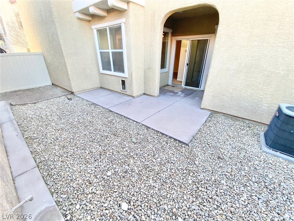 8569 Rhamus Court Las Vegas, NV 89149 - Photo 32 of 35 A low-maintenance yard features decorative gravel and a simple concrete path leading to a sliding glass door entry.