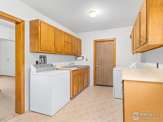 a utility room with cabinets washer and dryer