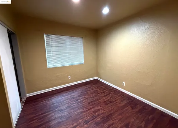 a view of a room with wooden floor and a window