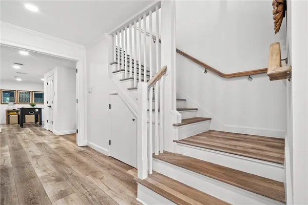 a view of a big room with wooden floor and windows