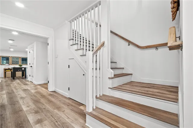 a view of a big room with wooden floor and windows