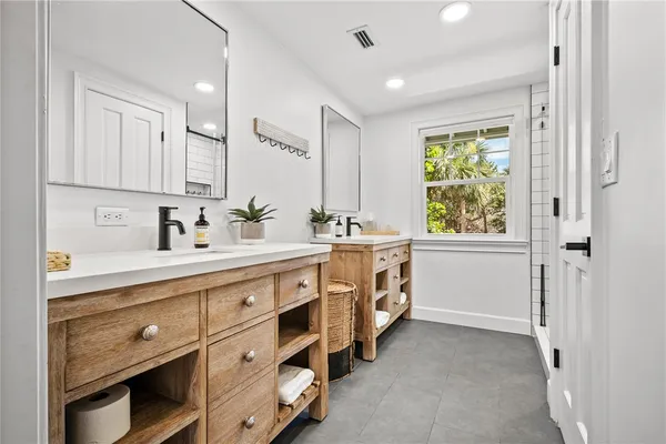 a spacious bathroom with a double vanity sink a mirror and a bathtub