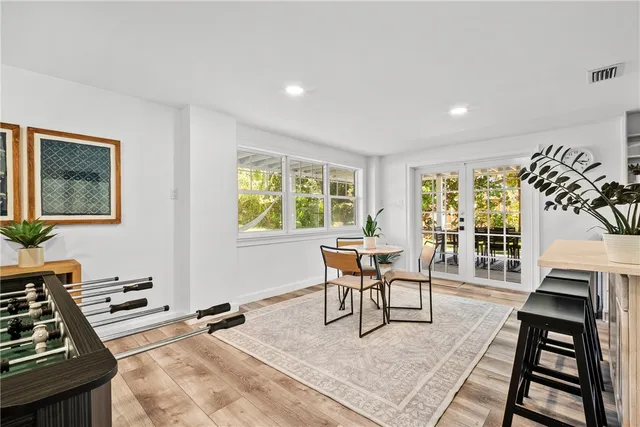 a living room with furniture a fireplace and a dining table with wooden floor