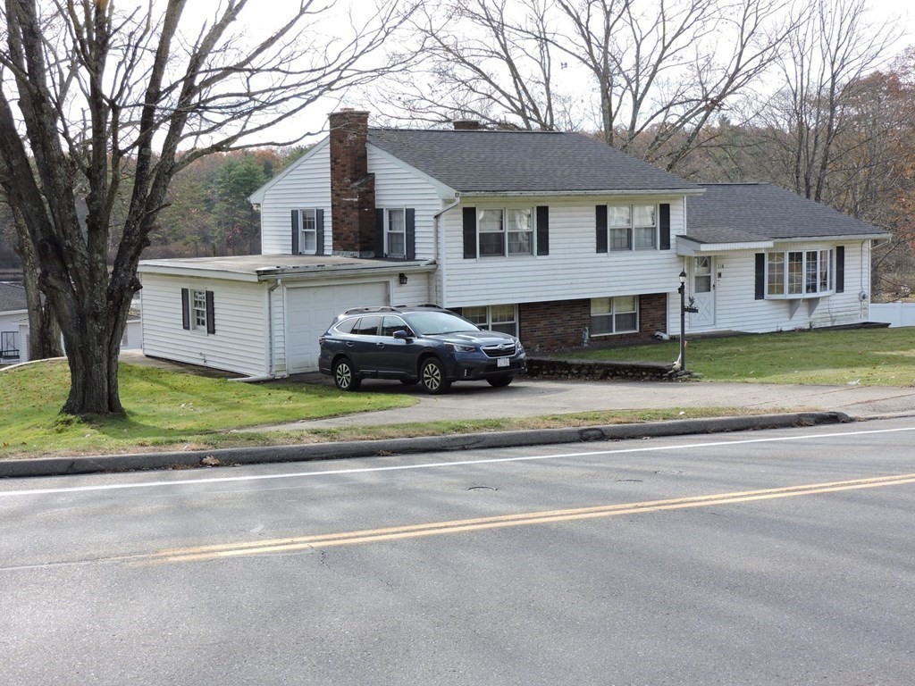 110 Gore Road Webster, MA 01570 - Photo 2 of 42 a front view of a house with a garden and trees