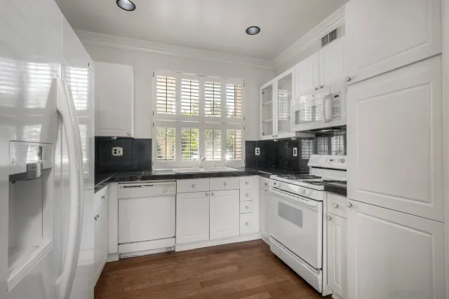 a kitchen with white cabinets and white appliances