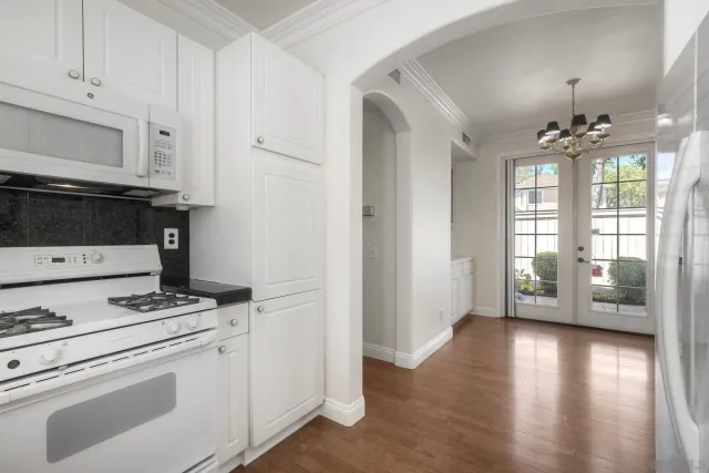 a view of kitchen with stove and cabinets