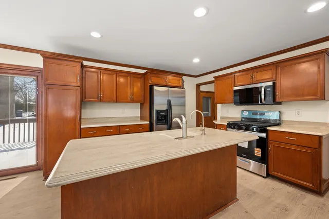 a kitchen with stainless steel appliances granite countertop a sink stove and refrigerator