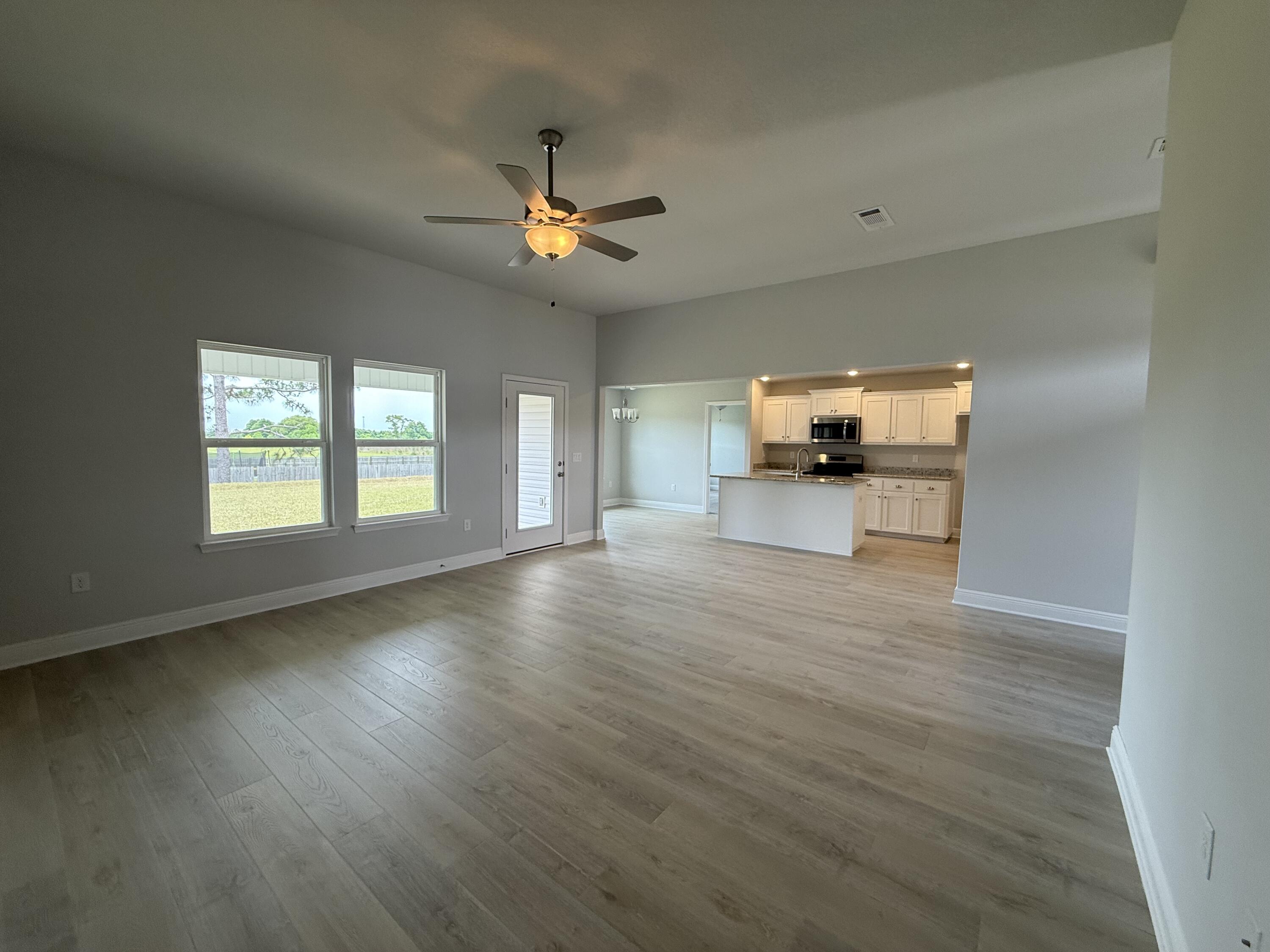 6002 Crocket Cove Crestview, FL 32539 - Photo 5 of 29 a view of a livingroom with furniture a ceiling fan and wooden floor