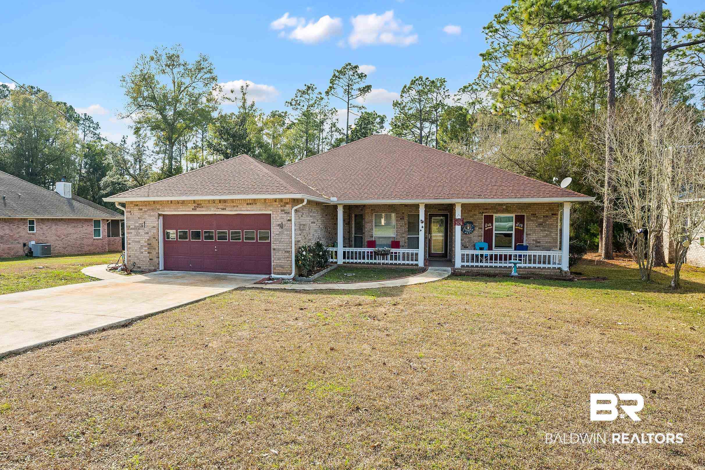2674 Pine Ridge Drive Lillian, AL 36549 - Photo 1 of 42 Single story home featuring a front lawn, a shingled roof, a porch, and driveway