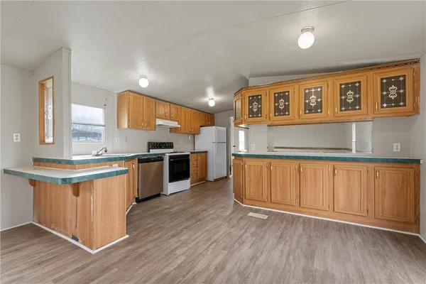 a kitchen with stainless steel appliances granite countertop a stove a sink and a refrigerator