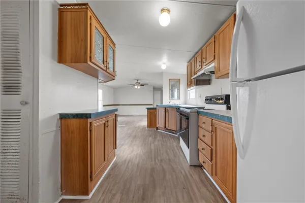 a kitchen with stainless steel appliances granite countertop a refrigerator a stove and a wooden floors