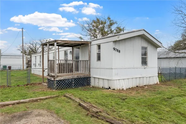 a white house that has tree in front of it