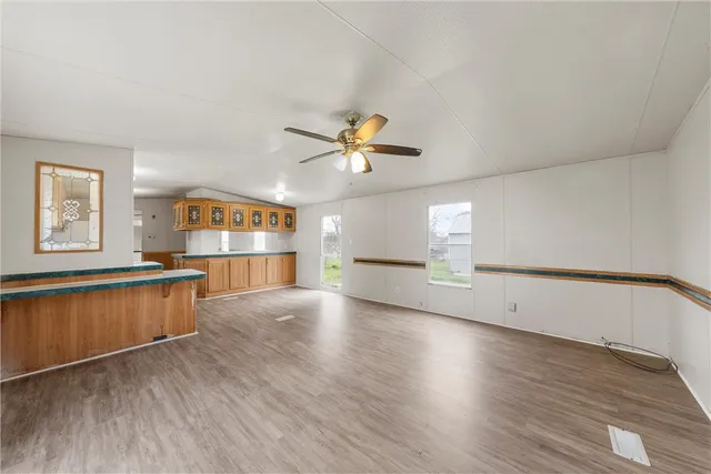 a view of an empty room with window and wooden floor
