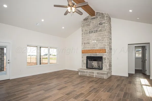an empty room with windows and fireplace