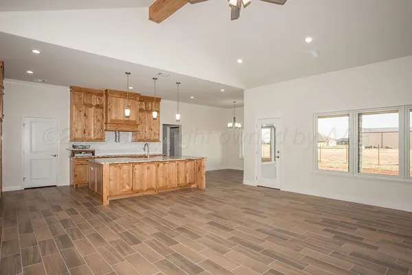 a large kitchen with stainless steel appliances a large counter top and a wooden floors