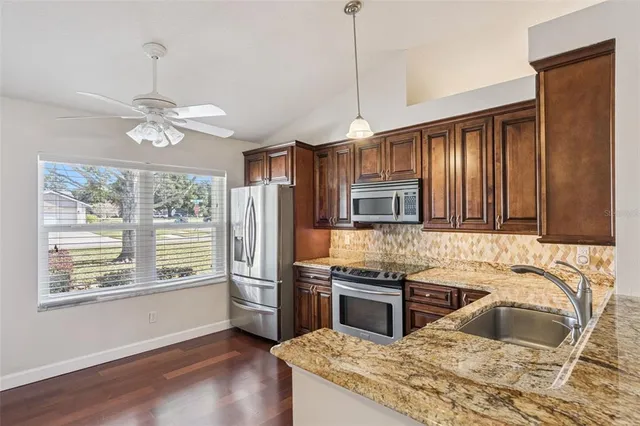a kitchen with stainless steel appliances granite countertop a sink stove and refrigerator