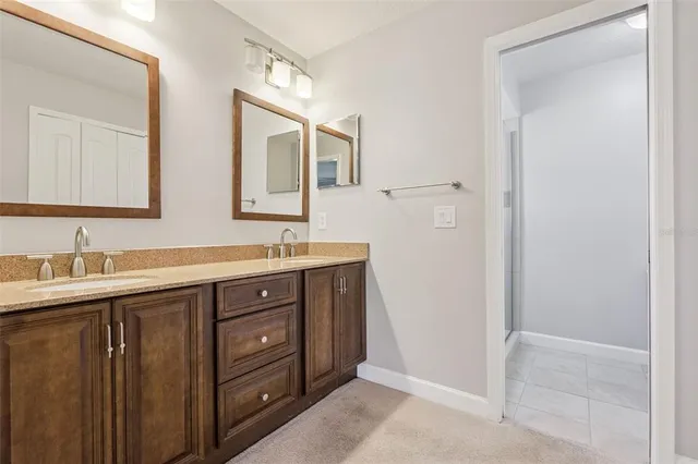 a bathroom with double sink and a mirror