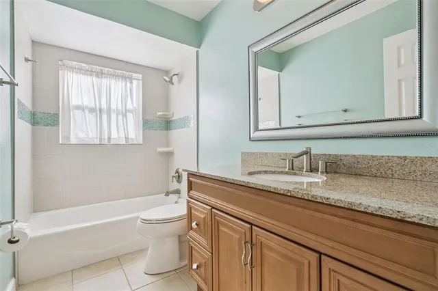 a bathroom with a granite countertop sink a toilet and a bathtub