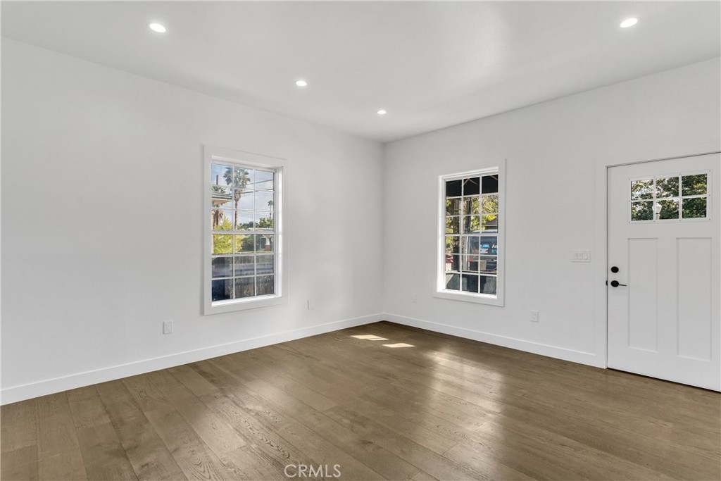3635 Locust Street Riverside, CA 92501 - Photo 5 of 25 an empty room with wooden floor and windows
