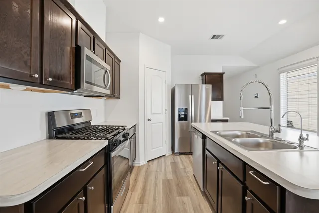 a kitchen with stainless steel appliances granite countertop a sink stove and refrigerator