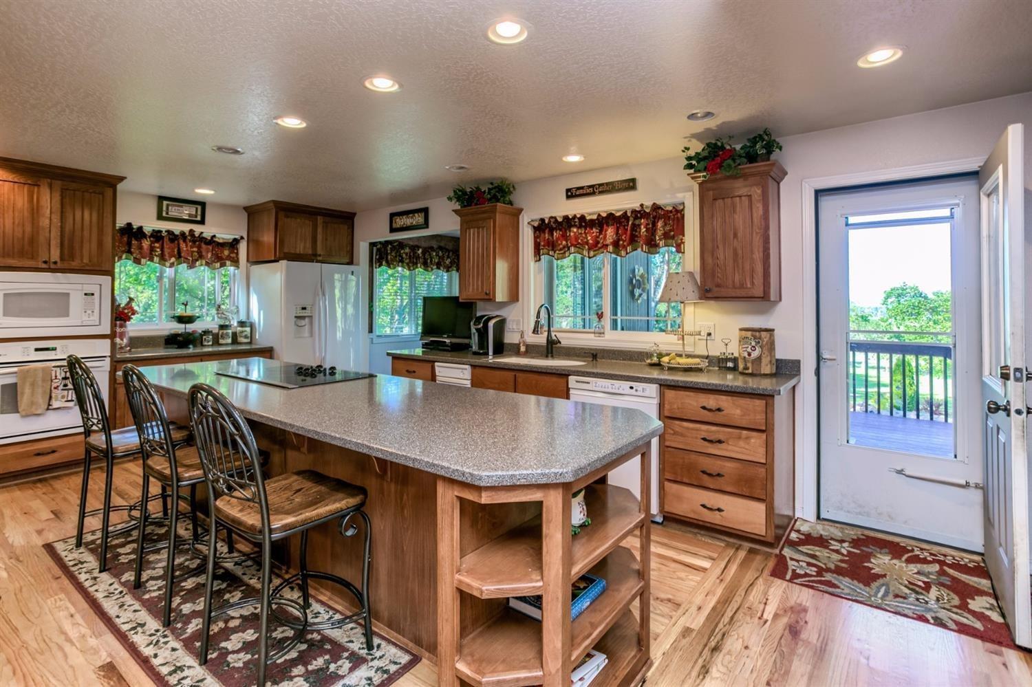 4110 Old Stage Road Central Point, OR 97502 - Photo 11 of 34 a kitchen with stainless steel appliances kitchen island granite countertop a table chairs and a refrigerator