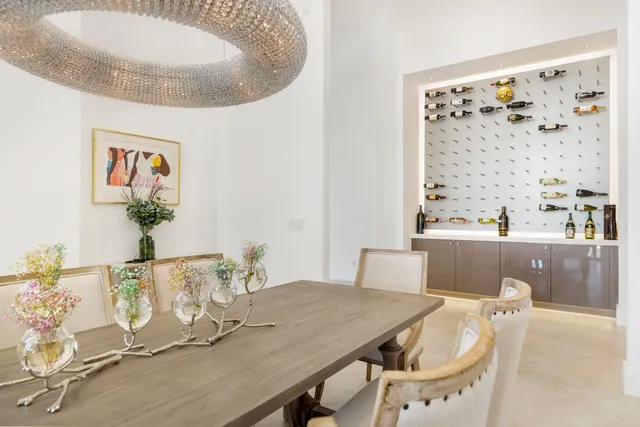 a dining room with furniture large windows and a chandelier