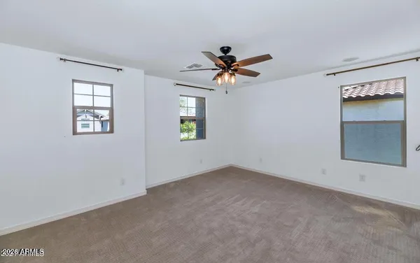 an empty room with a window and a fan
