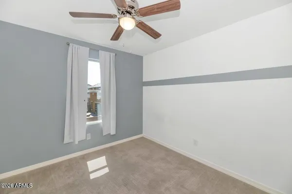 an empty room with closet and a chandelier fan