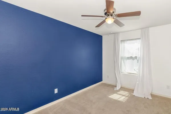 an empty room with windows and fan