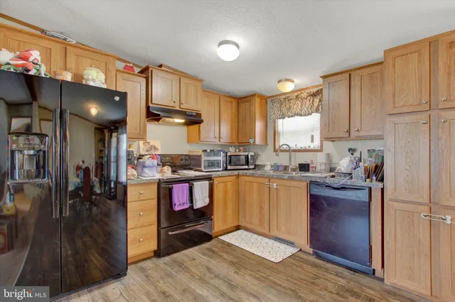 a kitchen with a refrigerator and a stove top oven