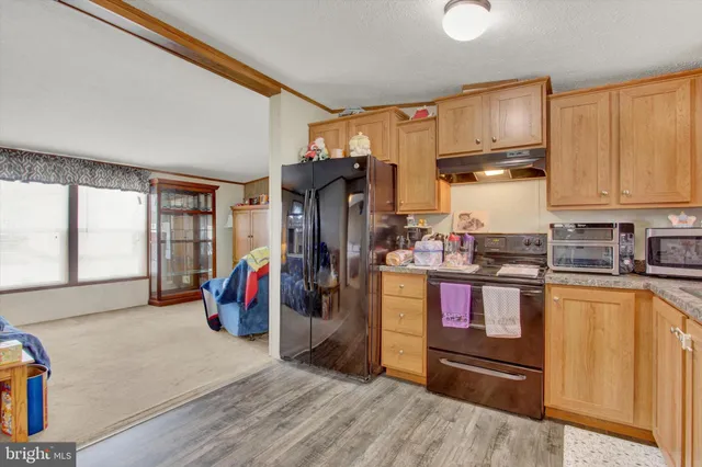 a kitchen with stainless steel appliances granite countertop a refrigerator and wooden cabinets