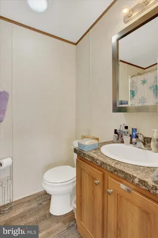 a bathroom with a granite countertop sink a toilet and a mirror