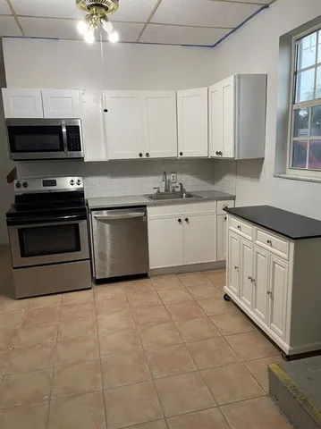 a kitchen with stainless steel appliances granite countertop a sink and a stove