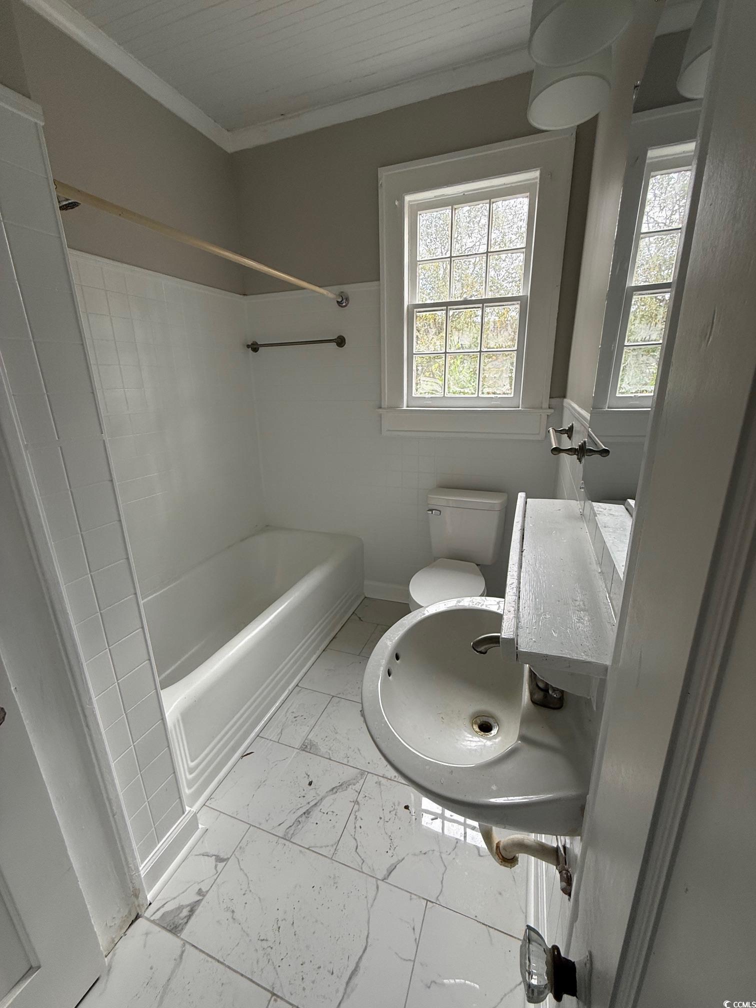 305 East Bamberg Street Latta, SC 29565 - Photo 11 of 13 Bathroom featuring ornamental molding, light marble finish floors, and tub / shower combination