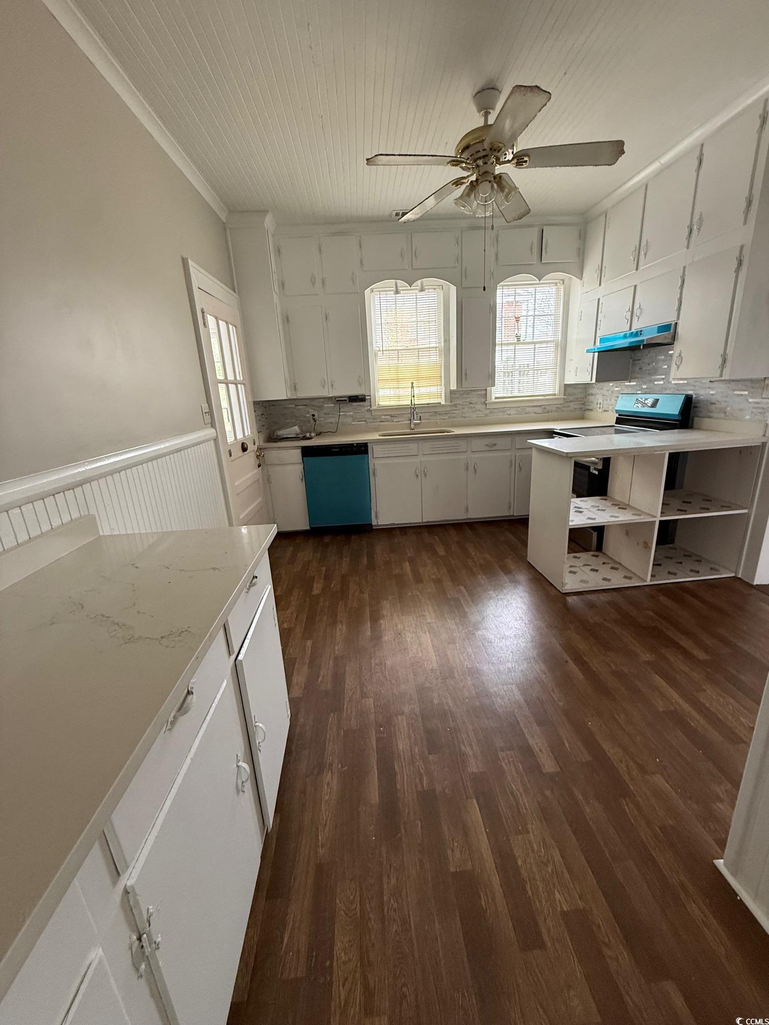 305 East Bamberg Street Latta, SC 29565 - Photo 10 of 13 Kitchen featuring light countertops, white cabinetry, healthy amount of natural light, dark wood-style flooring, and wooden ceiling