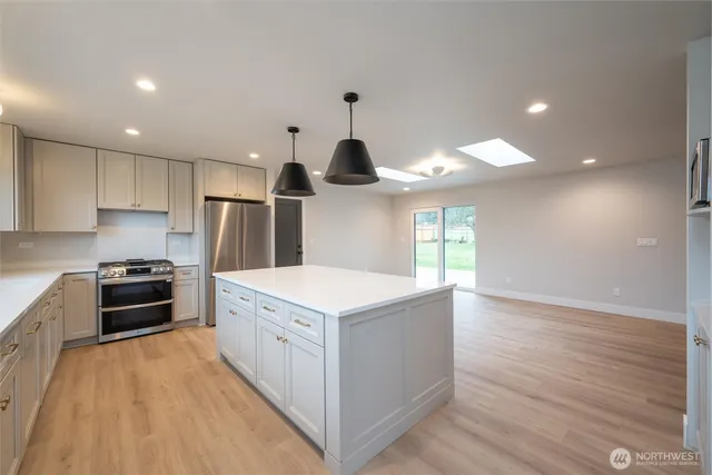 a kitchen with a stove a sink and a refrigerator