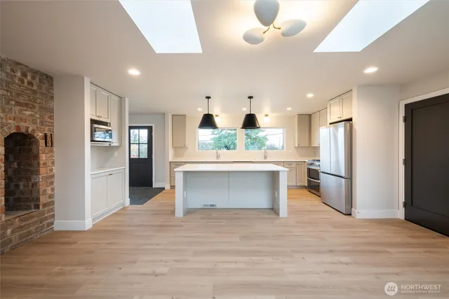 a kitchen with stainless steel appliances granite countertop a refrigerator and a stove top oven