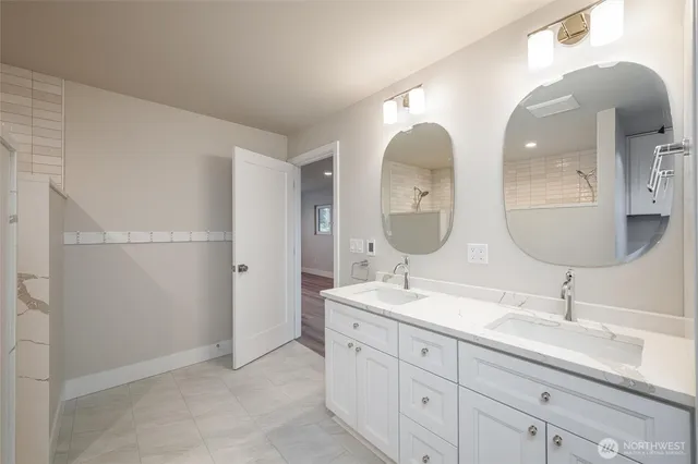 a bathroom with double vanity sinks and a mirror