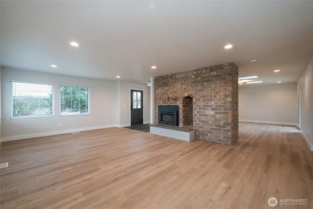 an empty room with wooden floor and fireplace
