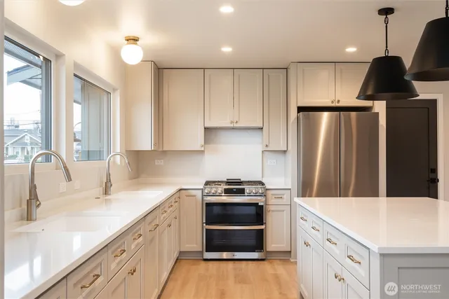 a kitchen with kitchen island granite countertop a sink stainless steel appliances and cabinets