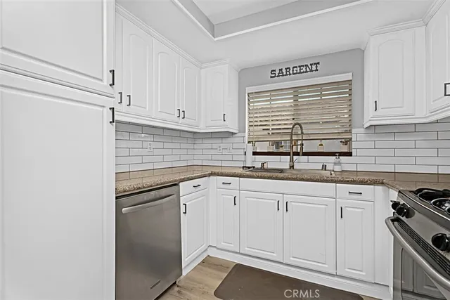 a kitchen with white cabinets and appliances