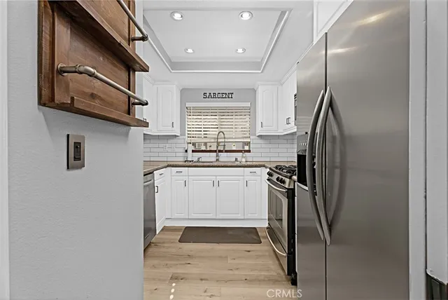 a kitchen with stainless steel appliances granite countertop a refrigerator and a stove