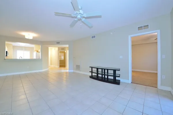 an empty room with windows and fan