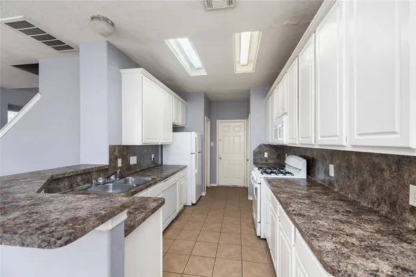 a kitchen with stainless steel appliances granite countertop a sink stove and cabinets