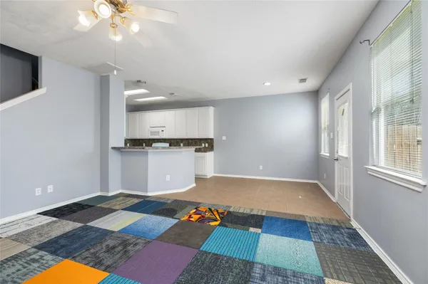 a view of a kitchen with a sink and an empty room