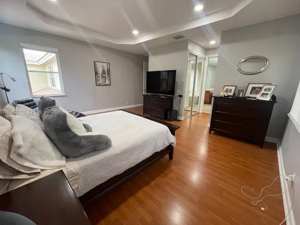a bedroom with a bed a mirror and a flat screen tv