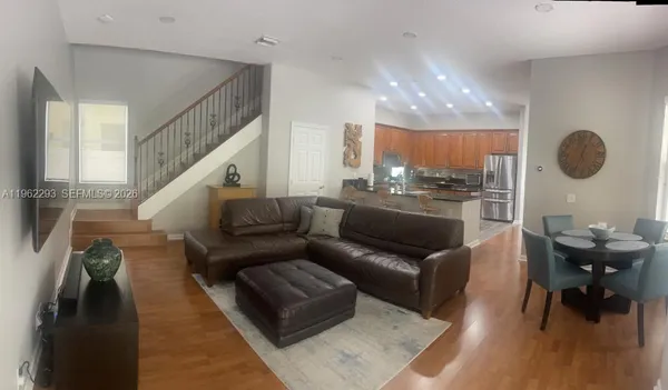 a living room with furniture and a wooden floor