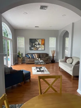 a living room with furniture a rug and a large window