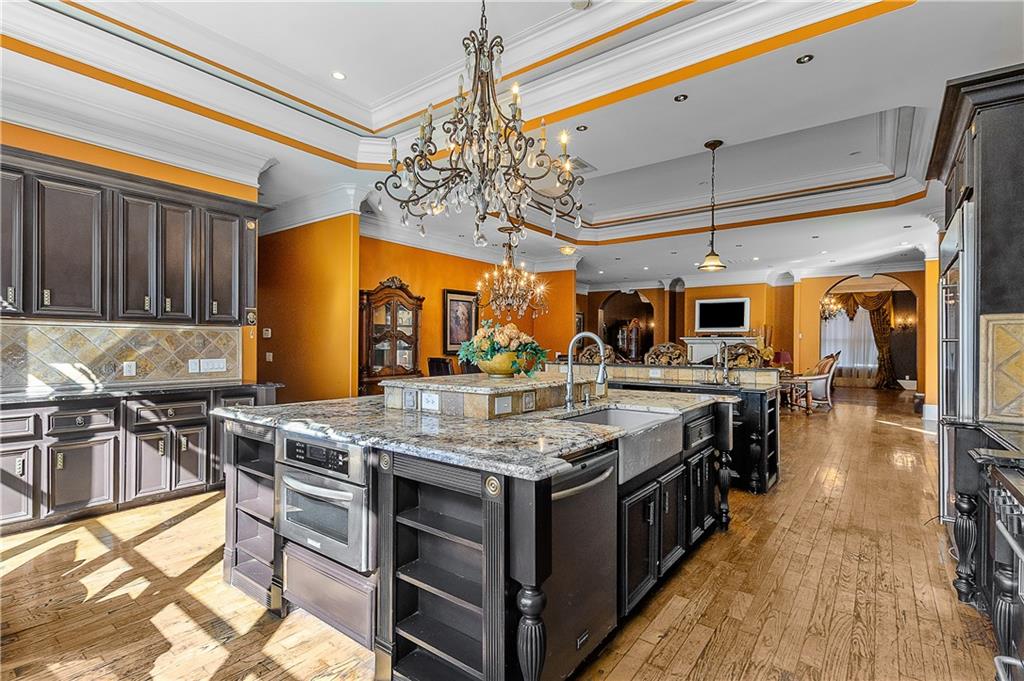 9830 Cedar Grove Road Fairburn, GA 30213 - Photo 13 of 55 a kitchen with stainless steel appliances granite countertop a large stove a sink dishwasher and chairs with wooden floor